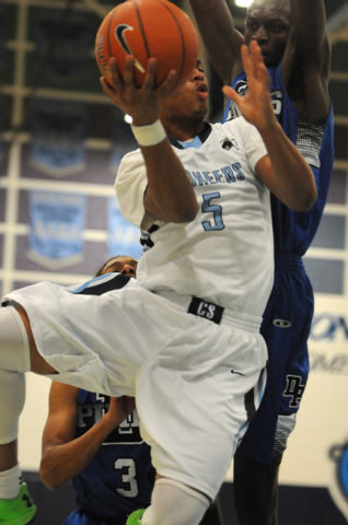 Canyon Springs Gerad Davis (5) goes up for a shot against Desert Pines Nate Grimes (24) and ...