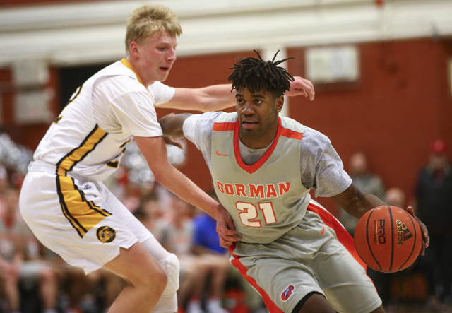 Bishop Gorman’s Christian Popoola (21) drives against Clark’s Trey Woodbury (22) ...