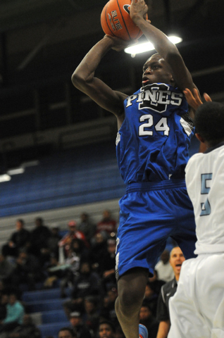 Desert Pines’ Nate Grimes (24) takes a shot over Canyon Springs’ Gerad Davis on ...