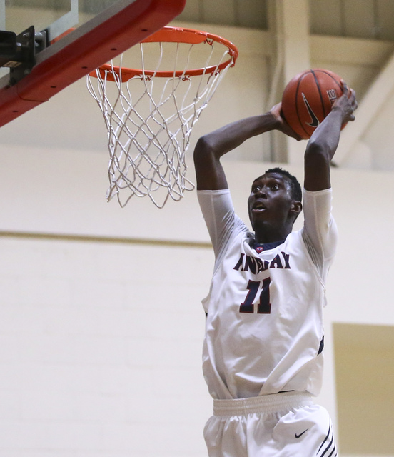 Findlay Prep forward Lamine Diane (11) goes up to dunk against Planet Athlete during a baske ...