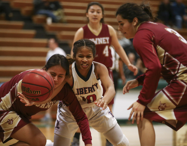 Liberty’s Janae Nickels (10) loses control of the ball while colliding with a Downey p ...