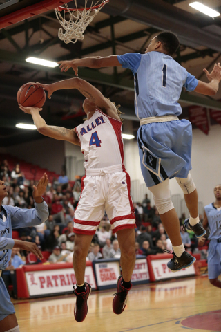 Canyon Springs senior Jordan Davis (1) jumps up to block a shot by Valley senior Taveon Jack ...
