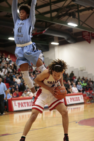 Valley senior Taveon Jackson (4) waits to shoot as Canyon Springs junior Zaahid Muhammad (10 ...