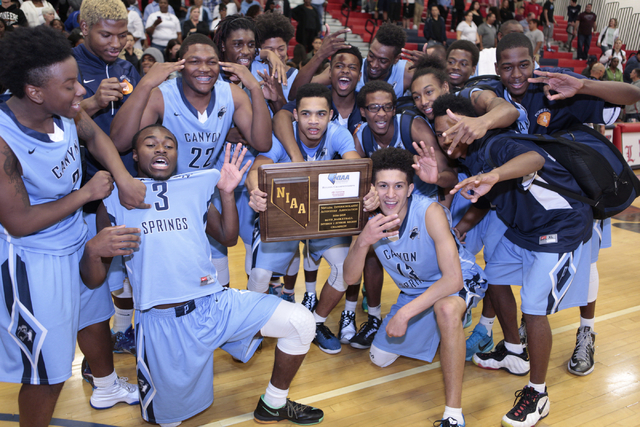 The Canyon Springs team poses with the trophy after beating Valley 65-63 in triple overtime ...