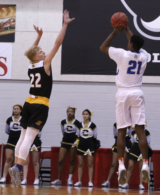 Bishop Gorman’s Christian Popoola (21) shoots over Clark’s Trey Woodbury (22) du ...