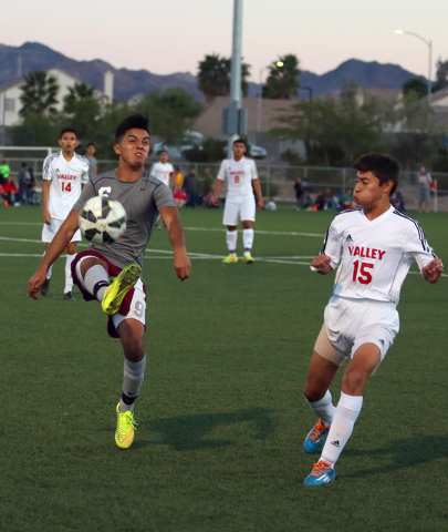 Cimarron-Memorial’s Danny Ceja, left, kicks the ball as Valley’s Alexis Jimenez ...