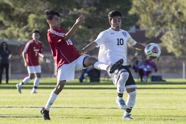 Jose Valles (19), from Valley High School, battles for the ball against Fernando Gomez (10), ...