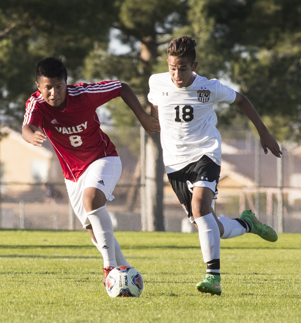 Andy Gonzales (8) from Valley High School, battles for the ball against Roberto Sotomayor (1 ...
