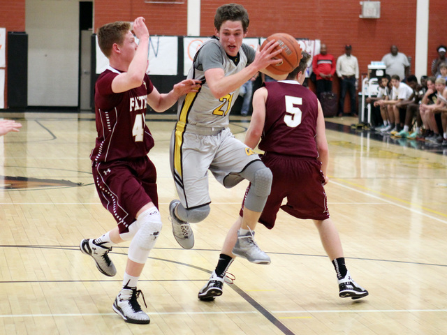Clark guard Carter Olsen skips between Faith Lutheran forward Elijah Kothe, left, and guard ...