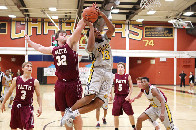 Clark forward Ty’Rek Wells gets past Faith Lutheran forward John Molchon for a basket ...
