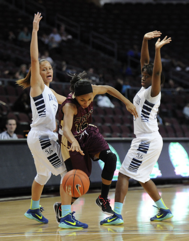 Faith Lutheran guard Haley Vinson (12) splits through Spring Valley guards Essence Booker, l ...