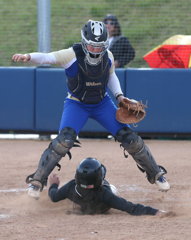 Reed catcher Ryia Grant jumps over Rancho’s Alexa Lira during NIAA DI softball action ...