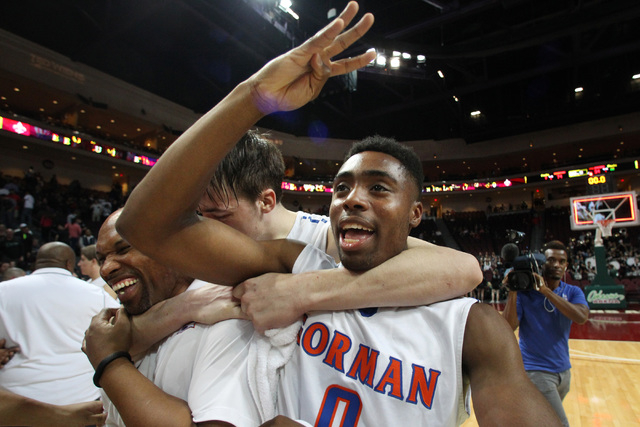 Bishop Gorman guard Ugo Amadi signals a fourth consecutive championship while being hugged b ...