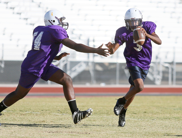 Sunrise Mountain senior quarterback Damon Heard, right, runs past Emmanuel Adeyemi during a ...