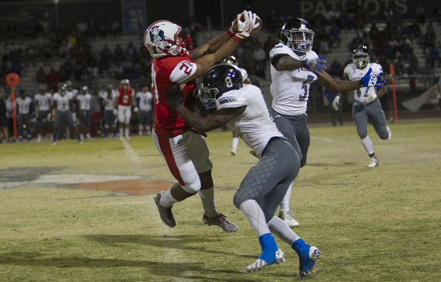Libertyճ Darion Acohido (21) catches a pass over Desert Pines’ Andrew Gray (8) during ...