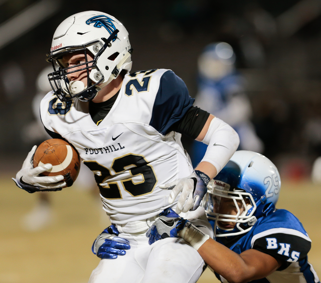 Foothill senior Brandon Hargis (23) attempts to move the ball down the field, as Basic junio ...