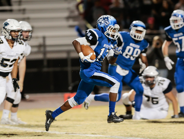 Basic senior Quison Owens (17) runs the ball as Foothill defensive players look on, during ...