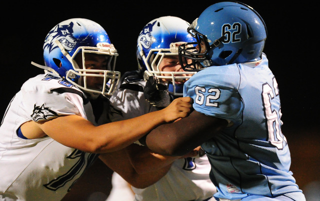 Basic High School guard Eddie Halstead, left, and Basic center Tyler Ames battle with Canyon ...