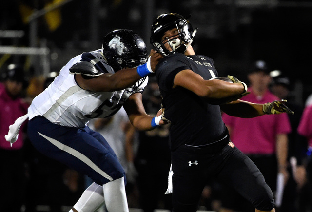 Shadow Ridge’s Byron Buckles (57) grabs Faith Lutheran’s Christian Marshall by t ...