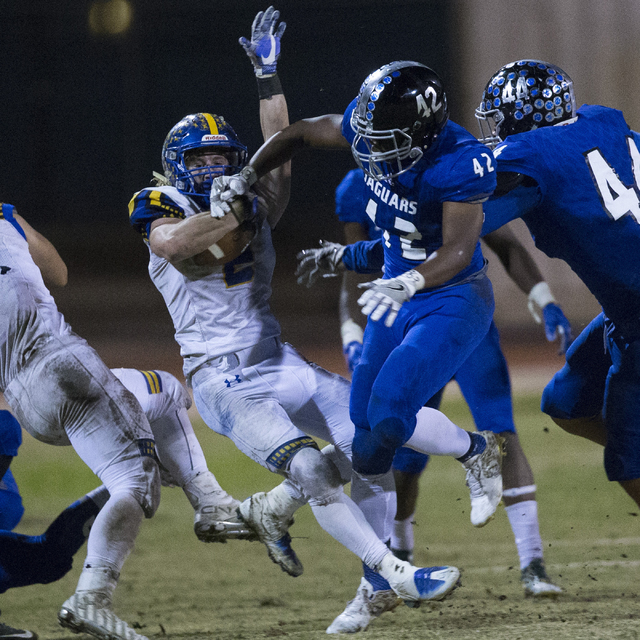 Moapa Valley’s Jacob Leavitt (2) is tackled by Desert Pines’ Jautae Collins (42) ...