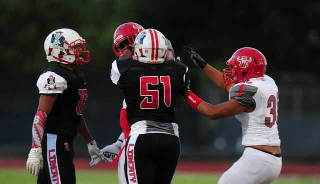 Liberty linebacker Syvone Sistrunk (51) shoves Arbor View defensive tackle Greg Rogers while ...
