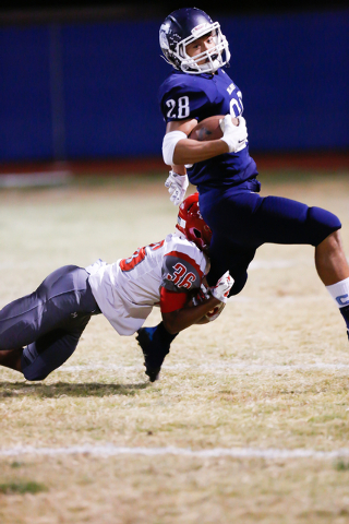 Arbor View’s Donnie Barfield (36) hangs on for a tackle of Centennial’s Dieyon S ...