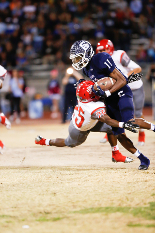 Arbor View’s Elijah Clark (25) makes a hard hit on Centennial’s Savon Scarver (1 ...