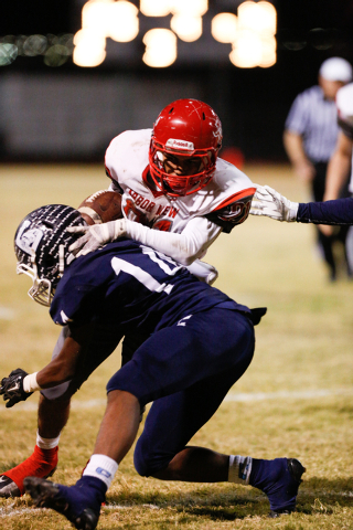 Centennial’s Justice Selmon (14) brings down Arbor View’s Charles Louch (21) in ...