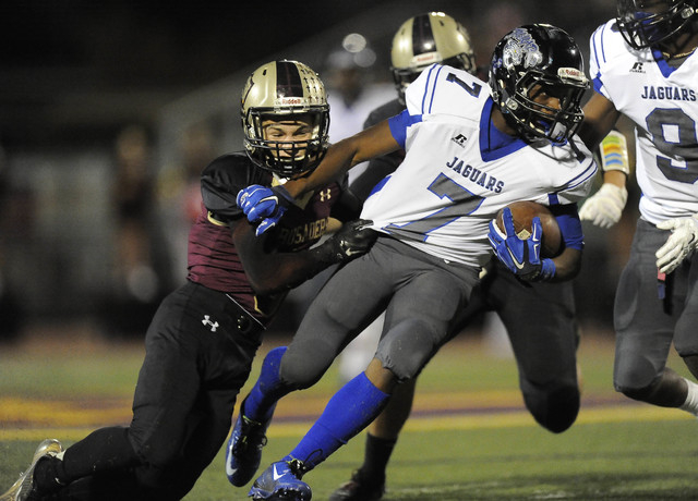 Desert Pines running back Isaiah Morris (7) is tackled by Faith Lutheran defensive back Robb ...