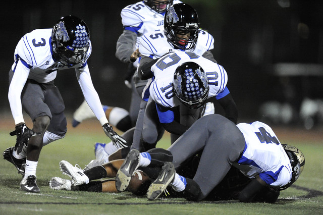 Desert Pines players Gianni Breland (3), Dillard Davis (5), and Jon McCoy (10) scramble to r ...