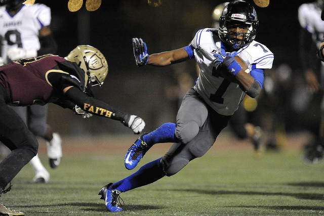 Desert Pines sophomore running back Isaiah Morris sidesteps a tackle attempt by Faith Luther ...