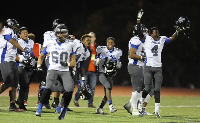 Desert Pines players celebrate their 34-27 victory over defending state champion Faith Luthe ...
