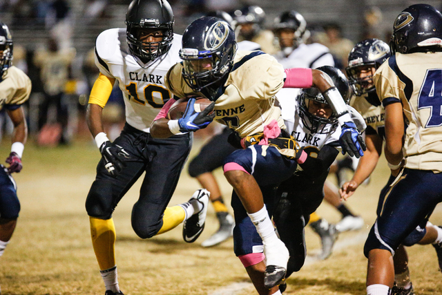 Cheyenne’s Corwin Bush (6) runs the ball attempting to break a tackle by a player from ...