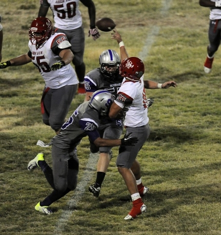 Arbor View quarterback Bryce Poster is drilled by Silverado linebackers Dallen Dunford (55) ...