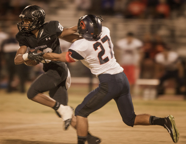 Palo Verde running back Isaac Woods,left, fights off Bishop Gorman cornerback Troy Wilewski ...