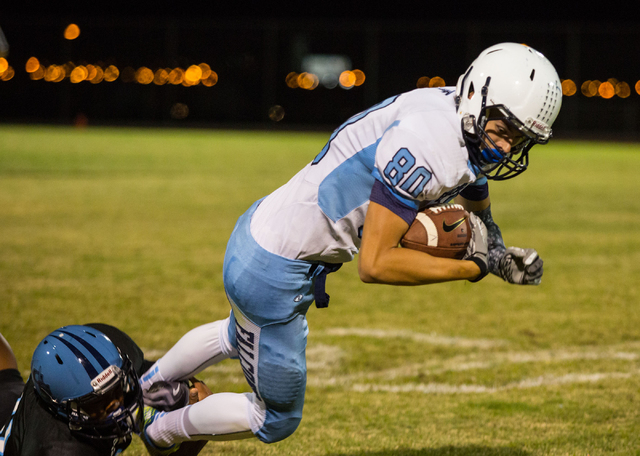 Foothill’s James Hagen (80) is tackled by Canyon Springs’ Christian Minor on Fri ...