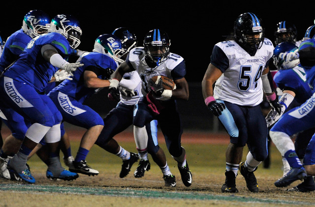 Canyon Springs’ Jerrod Blackwell (10) finds a hole as he carries the ball against Gree ...