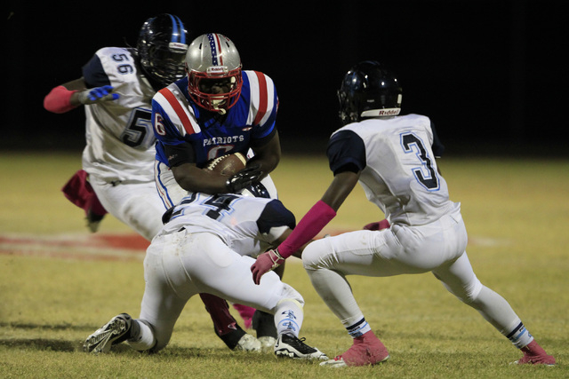 Liberty running back Calvin Tubbs is pursued by Canyon Springs defenders, from left, Melvin ...