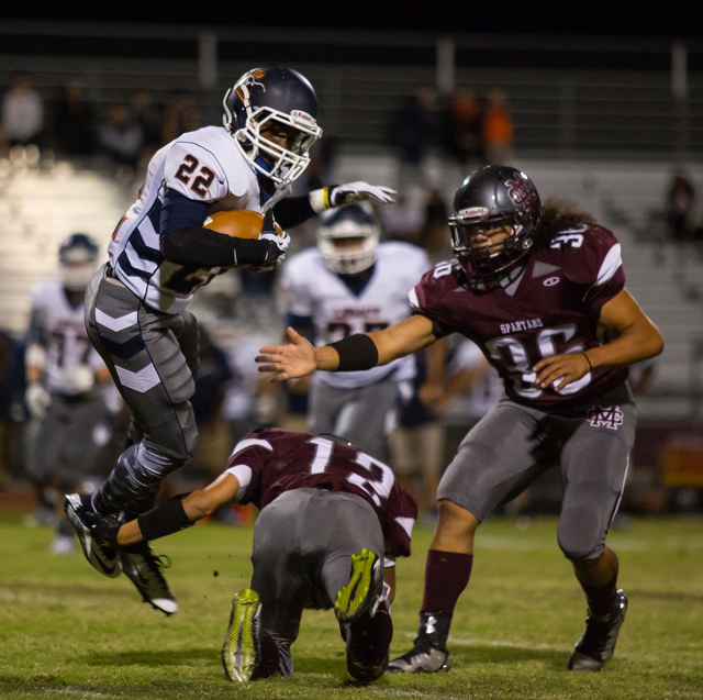 Legacy’s DeMichael Walker, left, avoids a Cimarron-Memorial tackler in the first quart ...