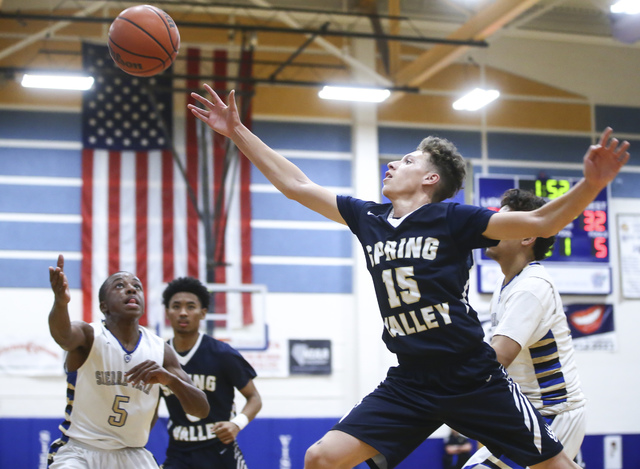 Spring Valley guard Ryan Frazier (15) goes up to get control of the ball during a basketball ...