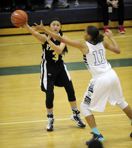 Faith Lutheran point guard Madison Bocobo passes in front of Spring Valley guard Kayla Harri ...