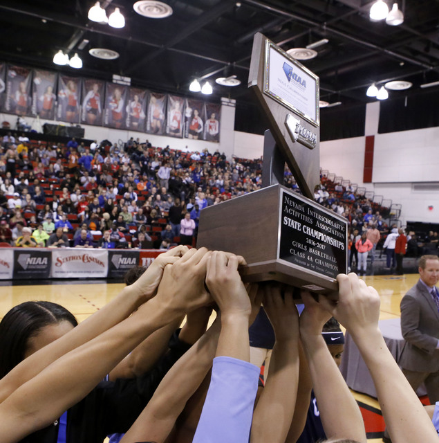 Centennial players thrusts their trophy into the air after winning their third straight Clas ...