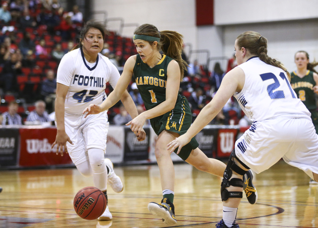 Bishop Manogue guard Katie Turner (1) drives to the basket between Foothill’s Trinity ...