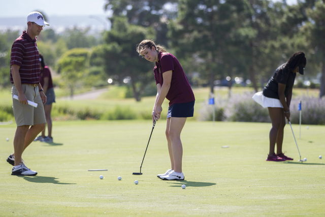 Faith Lutheran’s girls golf coach Mark Cheney, left, watches Olivia Vogel, 17, hit a p ...