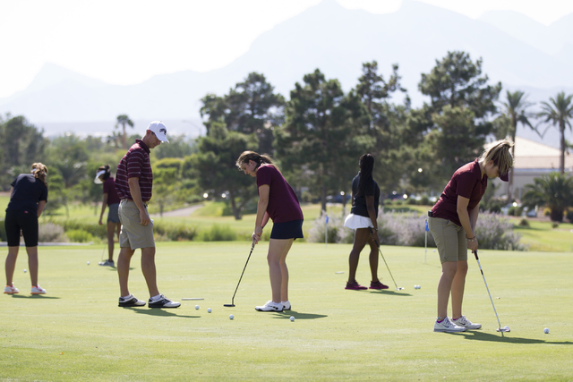 Faith Lutheran’s girls golf coach Mark Cheney, left, watches Olivia Vogel hit a putt d ...