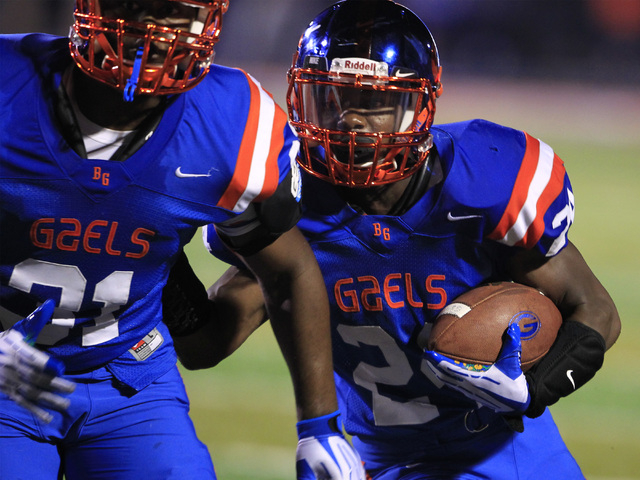 Bishop Gorman running back Russell Booze tucks in behind Carey Conner during their game agai ...