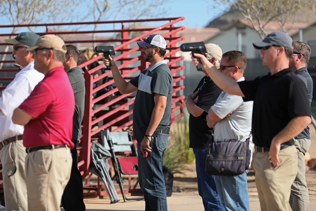 Scouts clock pitches and observers watch as Desert Oasis senior Nolan Kingham pitches during ...