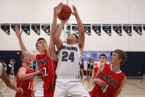 Lincoln County’s Derek Shumway blocks a shot by The Meadows forward Michael Jin during ...