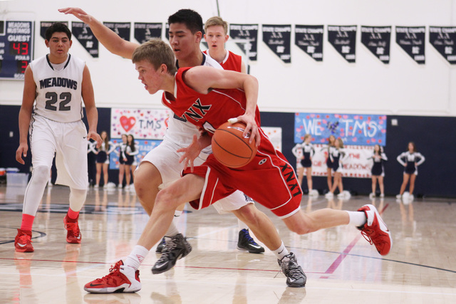 Lincoln County’s Mike Wood drives past The Meadows forward Michael Jin during their ga ...
