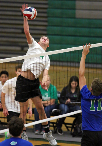 Palo Verde’s Parker Nelson, center, spikes the ball near Green Valley’s Dustin E ...